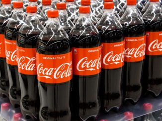Coca-cola botttles on a supermarket shelf.