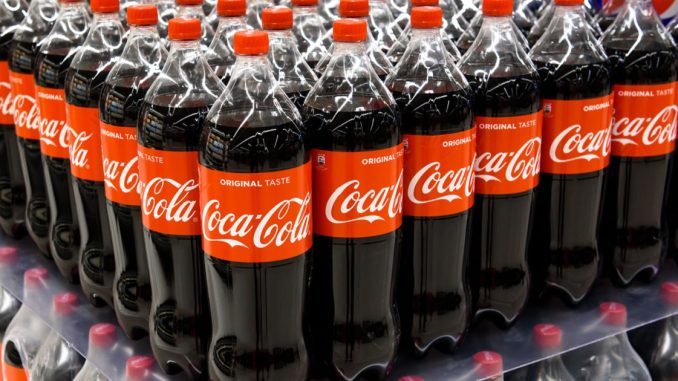 Coca-cola botttles on a supermarket shelf.