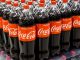 Coca-cola botttles on a supermarket shelf.